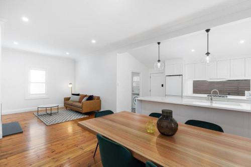 cocina y sala de estar con mesa de madera en Luxury Cottage Accommodation, en Mount Gambier