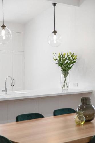 a table with a vase of flowers on a counter at Luxury Cottage Accommodation in Mount Gambier