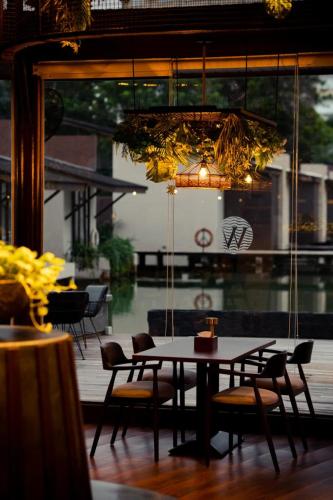 a dining room with a table and chairs and a chandelier at Woda Villa & Spa in Sengkuang