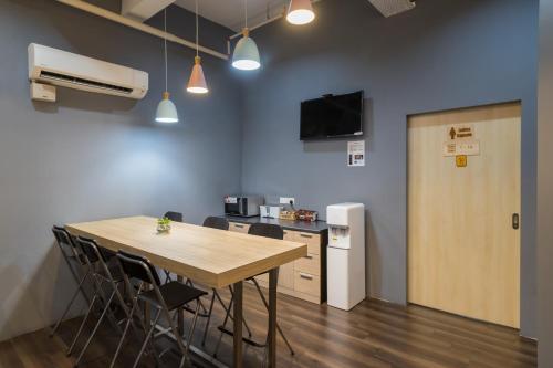 a conference room with a table and chairs and a refrigerator at Luma Casa Capsule Hotel, Sunsuria Forum Setia Alam in Shah Alam