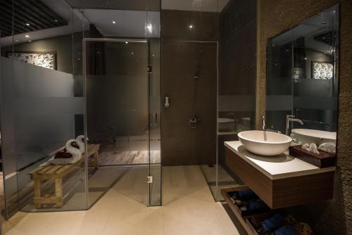 a bathroom with a glass shower and a sink at Woda Villa & Spa in Sengkuang