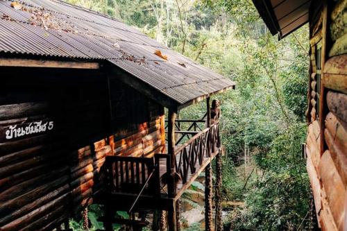 Cabaña con terraza de madera en el bosque en ชมไพรโฮมสเตย์ chomprai homestay, en Amphoe Chiang Dao