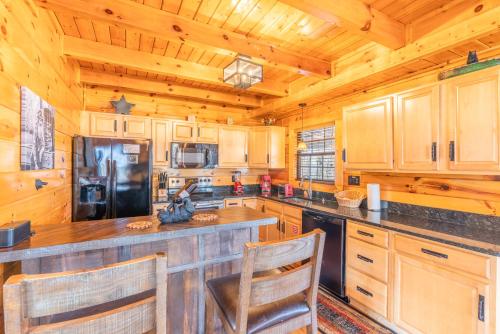a kitchen with wooden cabinets and a black refrigerator at Comfort Cabin Bearway To Heaven w Private Hot Tub in Pigeon Forge