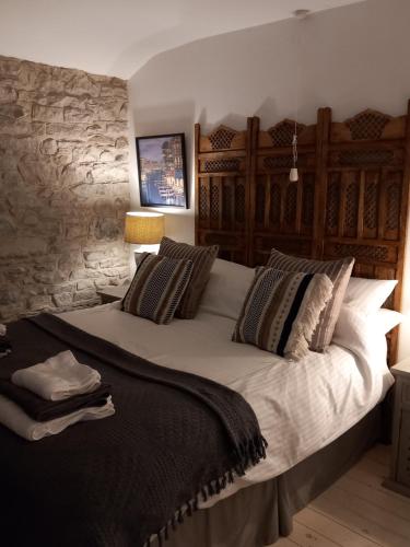 a bedroom with a large bed with a stone wall at Little Pinfold Cottage in Skipton