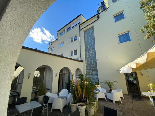 ein Torbogenblick auf ein Gebäude mit Tischen und Stühlen in der Unterkunft Hotel Michael in Gerasdorf bei Wien