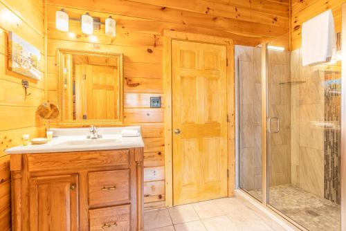 a bathroom with a sink and a shower at Comfort Cabin Bearway To Heaven w Private Hot Tub in Pigeon Forge