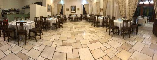 un comedor con mesas y sillas en un restaurante en Hotel Casale 900, en Paestum