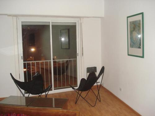 two chairs and a table in a room with a window at Mar Del Plata Loft in Mar del Plata