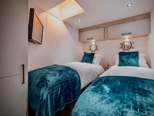 two beds in a room with blue sheets at Sandpearl Suite Apartments in Lytham St Annes