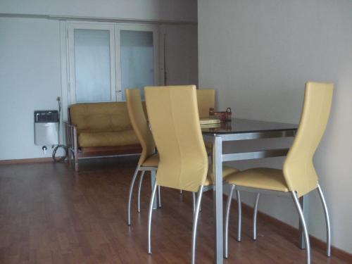 a dining room with a table and yellow chairs at Mar Del Plata Loft in Mar del Plata