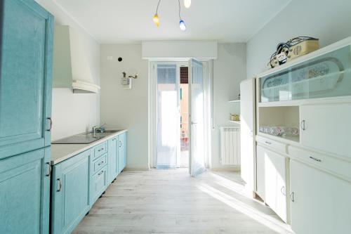 cocina con armarios azules y suelo blanco en 097 - Casa Stella a Riva Trigoso, 300 metri da mare e spiaggia, POSTO AUTO PRIVATO GRATIS, en Sestri Levante