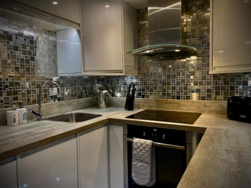 a kitchen with a sink and a stove at Sandpearl Suite Apartments in Lytham St Annes
