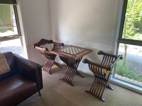 a room with a table and chairs and a couch at The Delightful Tee House - Kilmore in Kilmore