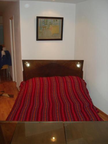 a bed with a red striped comforter in a room at Mar Del Plata Loft in Mar del Plata