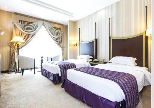 um quarto de hotel com duas camas e uma janela em Tourist Hotel em Doha