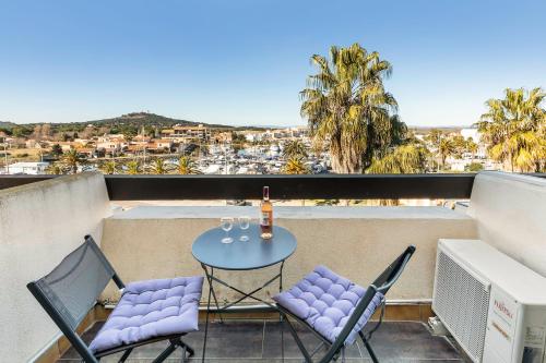 un patio avec une table et des chaises sur un balcon dans l'établissement Sunset 755 Naturist Port Nature, au Cap d'Agde