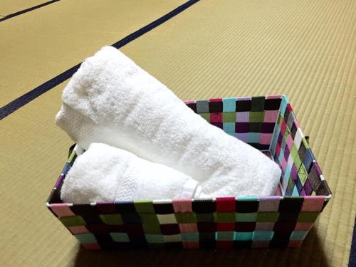 uma caixa cheia de meias brancas sobre uma mesa em ゲストハウスさくら Guesthouse Sakura em Sukumo