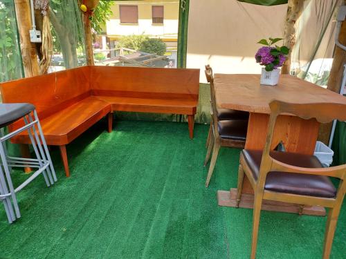eine Bank und einen Tisch sowie einen Tisch und Stühle in der Unterkunft Villetta Rosa in Lavena Ponte Tresa