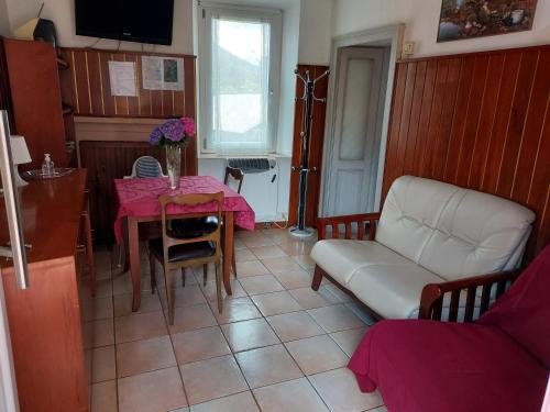 sala de estar con mesa y sofá en Villetta Rosa, en Lavena Ponte Tresa