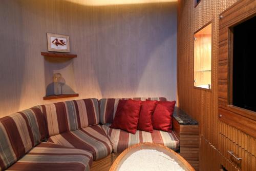 a living room with a couch with two red pillows at THE skM TOKYO HOTEL & DINING in Tokyo