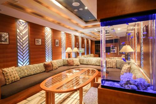 a living room with a couch and a fish tank at THE skM TOKYO HOTEL & DINING in Tokyo