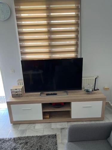 a television on a wooden stand in a living room at Smile studio in Drama