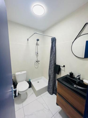 une salle de bain blanche avec des toilettes et un lavabo dans l'établissement Studio LA GRANDE MOTTE 50m PLAGE - 50m PORT Centre Ville, à La Grande Motte