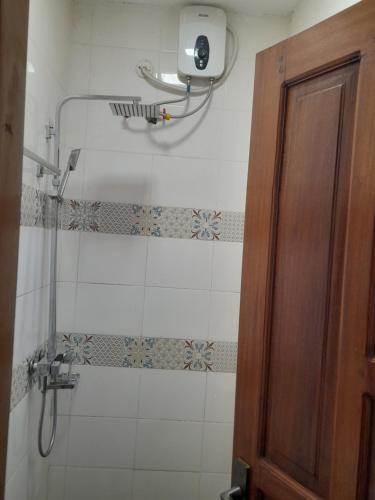 a bathroom with a shower with a glass door at Ella Apartment Albert Cook Road in Kampala