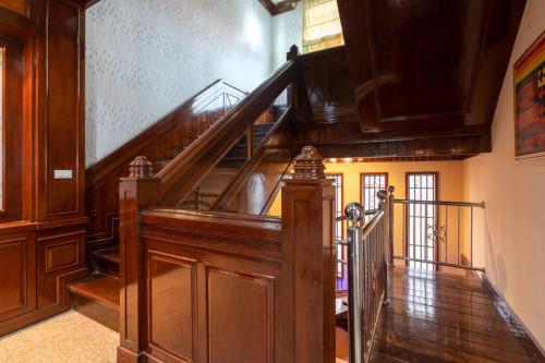 a hallway with a wooden staircase with a wooden railing at Angel Pool Villa Phuket - SHA Extra Plus in Phuket Town