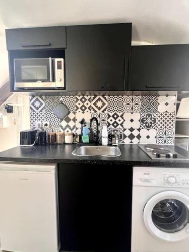 une cuisine avec un évier et un micro-ondes dans l'établissement Cosy studio next to the Champs-Élysées avenue!, à Paris