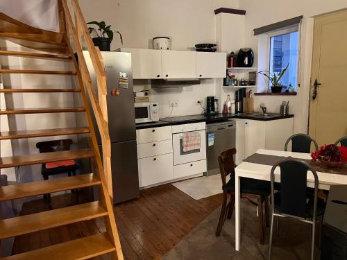 uma cozinha com uma mesa e uma cozinha com uma escada em Petite maison choux em Bouillon