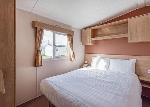 a bedroom with a large bed and a window at Woodlands Hall in Ruthin