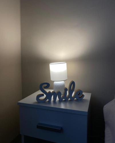 una cómoda azul con una lámpara encima en Apartman Smile en Čačak