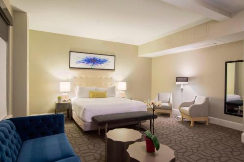 ein Hotelzimmer mit einem Bett und einem Sofa in der Unterkunft Magnolia Hotel Denver, a Tribute Portfolio Hotel in Denver