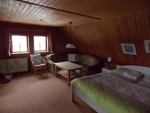 Saupsdorf的住宿－Pension Gaststätte Tannenhof，一间卧室配有一张床、一张沙发和一张桌子