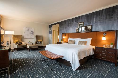 una habitación de hotel con una cama grande y una silla en Magnolia Hotel Houston, a Tribute Portfolio Hotel, en Houston
