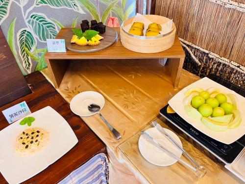 a table with two plates of fruit on it at Kenting Summerland Garden Resort in Eluan