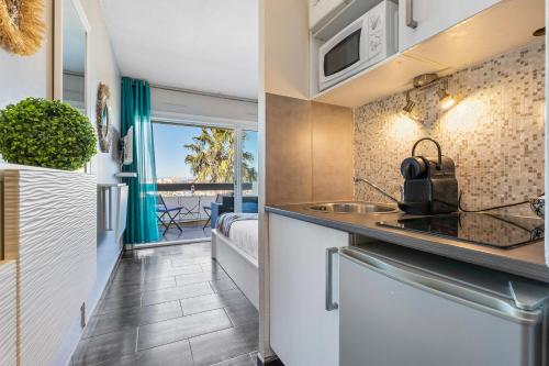 une cuisine avec un évier et un plan de travail dans l'établissement Sunset 755 Naturist Port Nature, au Cap d'Agde