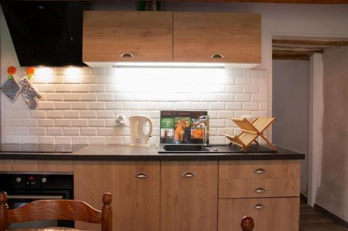 a kitchen with wooden cabinets and a white brick wall at Gîte de la Grange in Saint-Pardoux