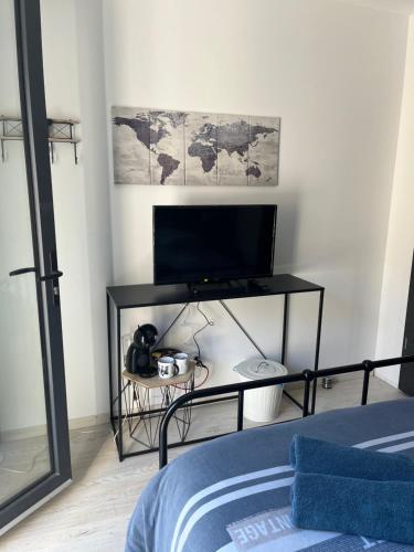 a bedroom with a television and a table with a bed at Chambre double indépendante AVIATEUR au sein du domaine PASSELOUP in Liergues