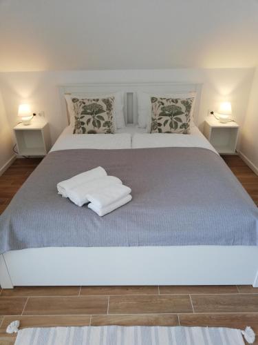 a bedroom with a large bed with two lamps at Zöld Terasz Vendégház in Egerszalók