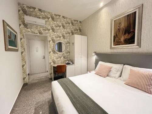 sypialnia z dużym białym łóżkiem i biurkiem w obiekcie Monza City Rooms & Studios w mieście Monza