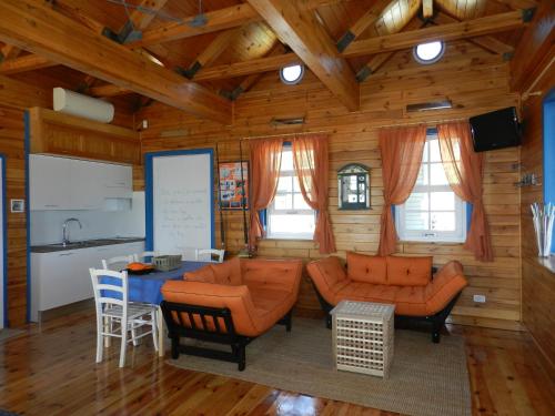 a living room with orange couches and a table at Ittiturismo Il Vecchio e il Mare in Grottammare