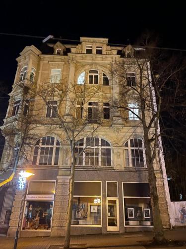 ein großes Steingebäude mit Fenstern in der Nacht in der Unterkunft Apartamento Plauen in Plauen