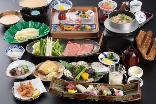 uma mesa com várias bandejas de comida em Onyado Shikishima-kan em Kotohira