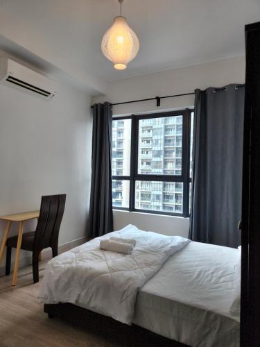 a bedroom with a bed and a desk and a window at Cozy 2BR APT @Ampang Embassy Row in Kuala Lumpur