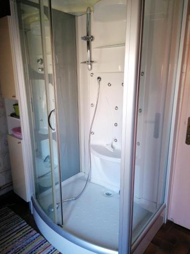 une douche avec une porte vitrée dans une salle de bain dans l'établissement Sam Bott, à Chambon-sur-Voueize