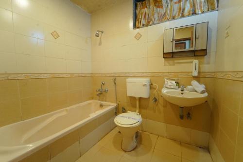 uma casa de banho com um WC, um lavatório e uma banheira em Sharayu Holidays Valley View em Panchgani