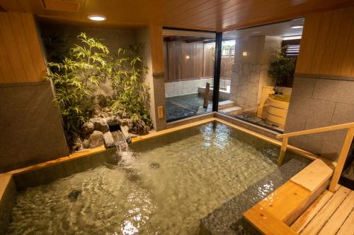 uma piscina de água num quarto com em Onyado Shikishima-kan em Kotohira