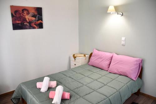 Cette petite chambre comprend un lit avec des oreillers roses et roses. dans l'établissement Sitos Home, à Sparte